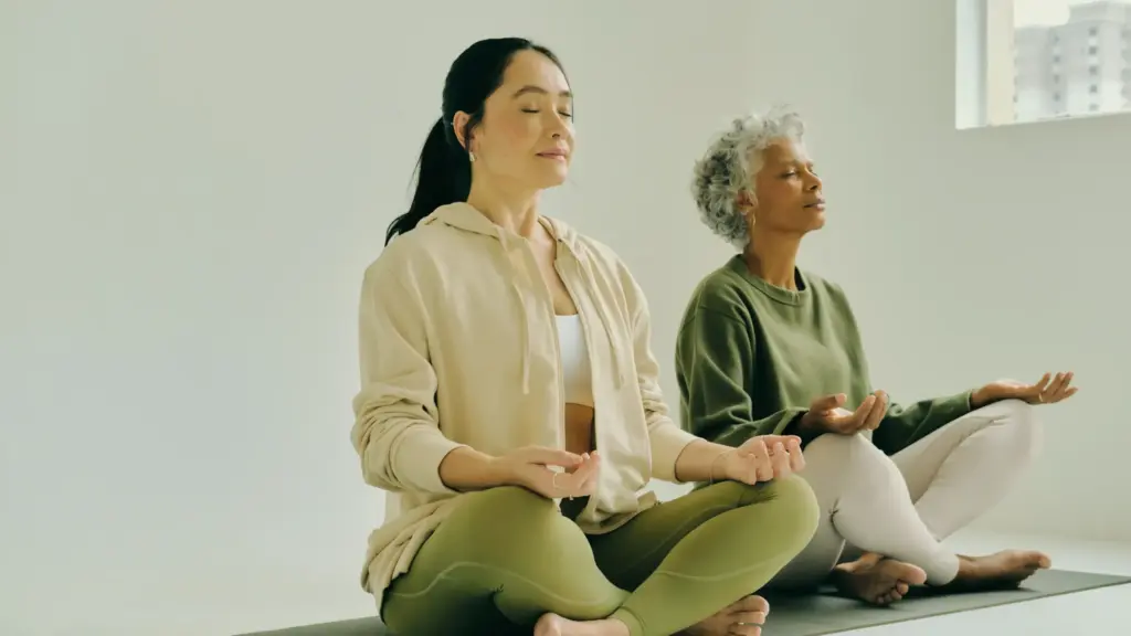 two women meditating on yoga mat