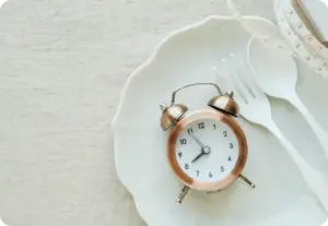 measuring tape, fork and alarm clock displayed on the plate