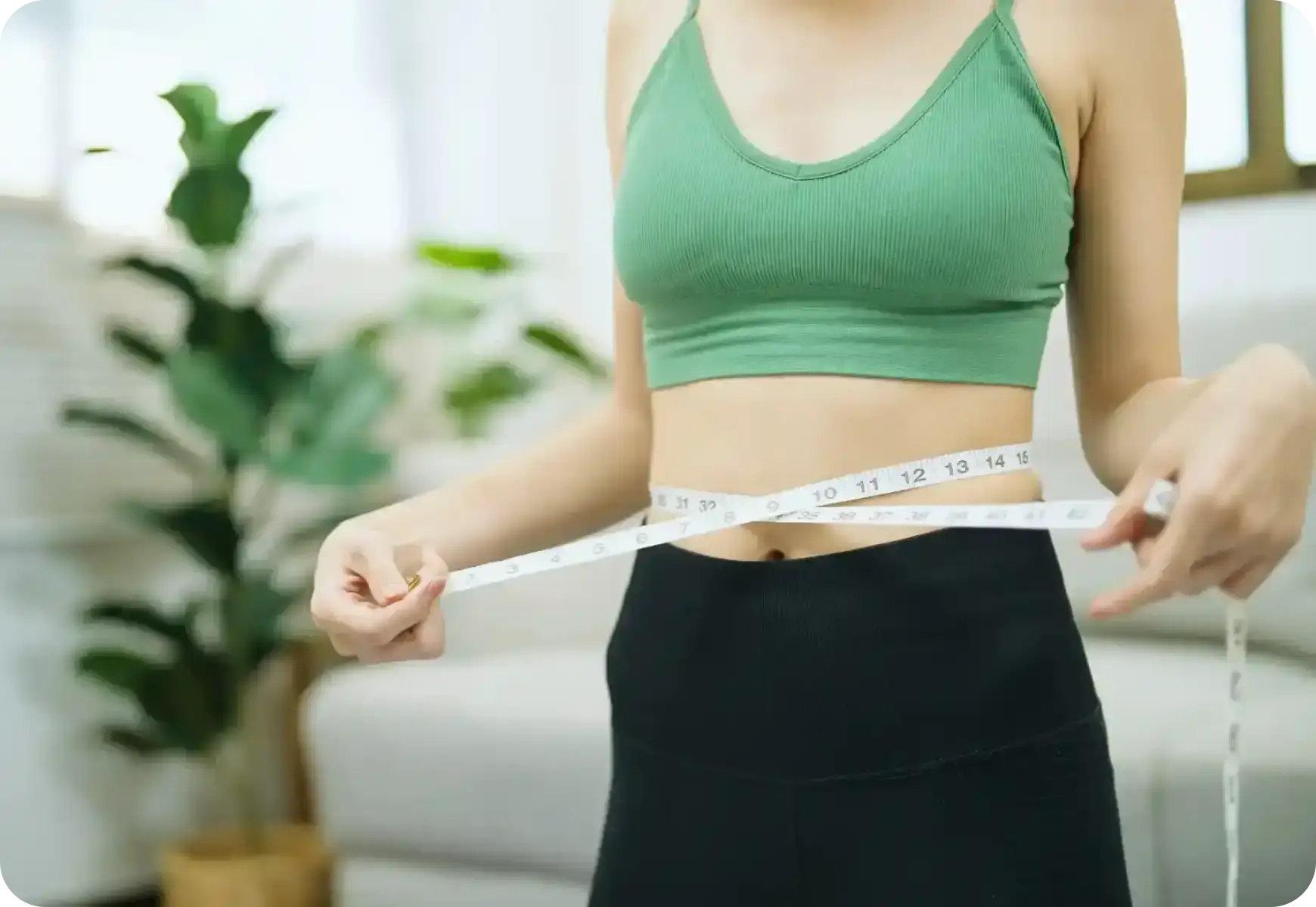 woman using measuring tape to measure waist size