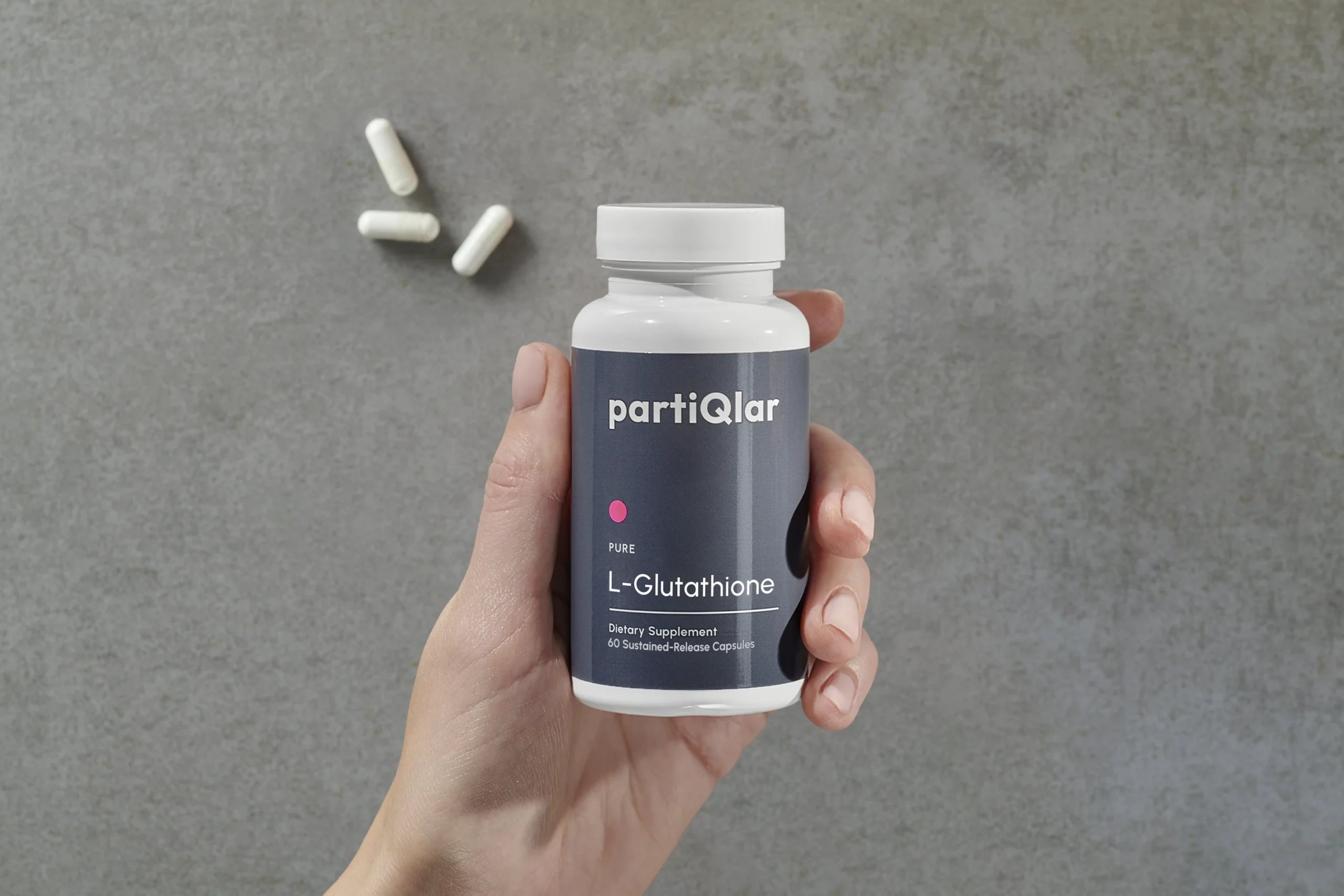 woman holding partiqlar l-glutathione supplements in hand