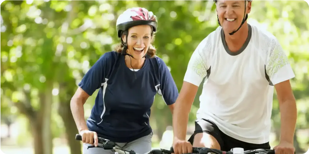 elderly couple happily riding bycicle