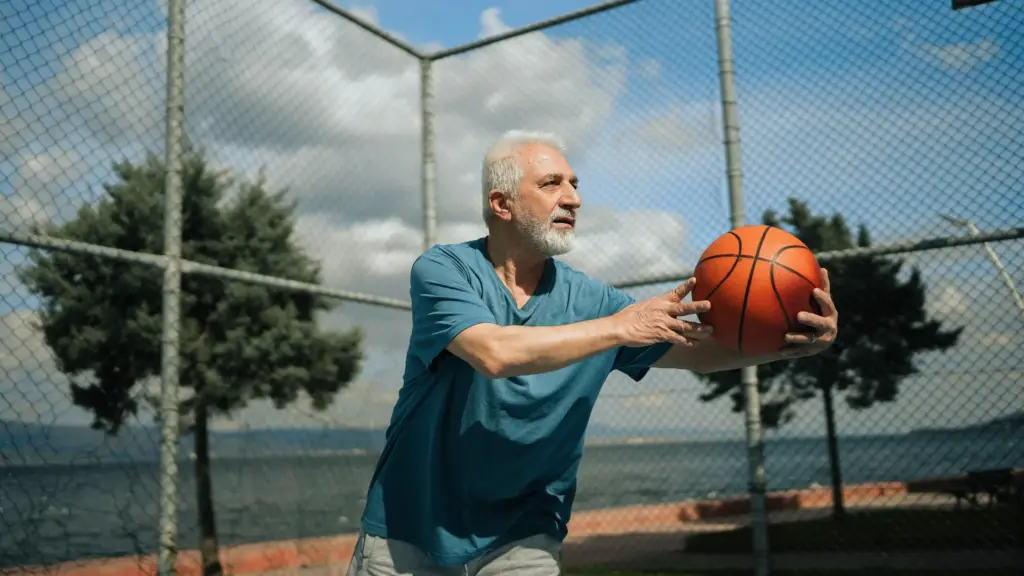 middle aged man playing basketball in nature